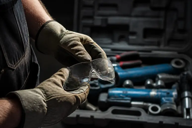 Gants de travail et lunettes de protection de plombier, symboles essentiels de sécurité sur le chantier.