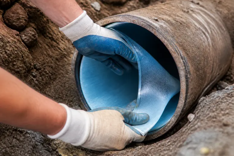 Pose d'un revêtement en résine pour le chemisage d'une canalisation d'eaux usées.