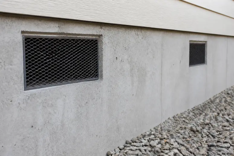 Grilles d'aération sur un mur de fondation pour ventiler le vide sanitaire