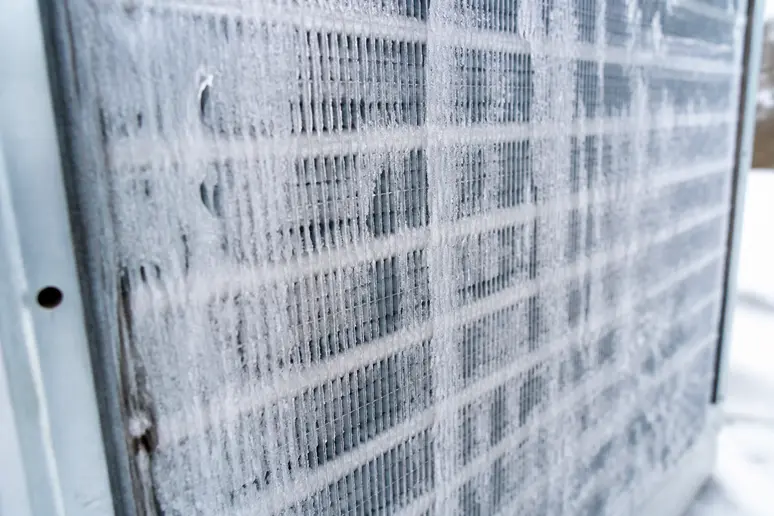 Givre recouvrant les ailettes de l'unité extérieure d'une pompe à chaleur par temps froid.