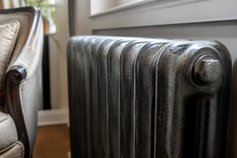 Radiateur en fonte ancien à haute température installé dans une pièce de vie