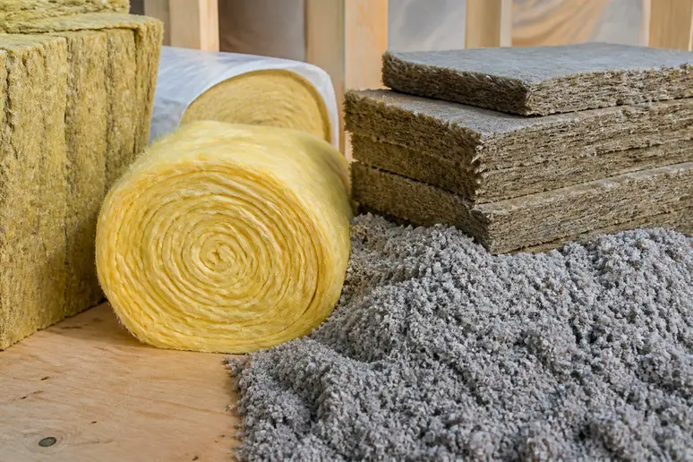 Rouleaux et panneaux de laine de verre et ouate de cellulose, prêts à être posés pour l'isolation.