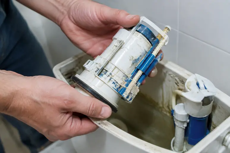 Démontage d'un robinet flotteur de chasse d'eau entartré pour un nettoyage au vinaigre